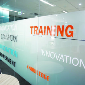 Window signs in an office with graphic designs and lettering.